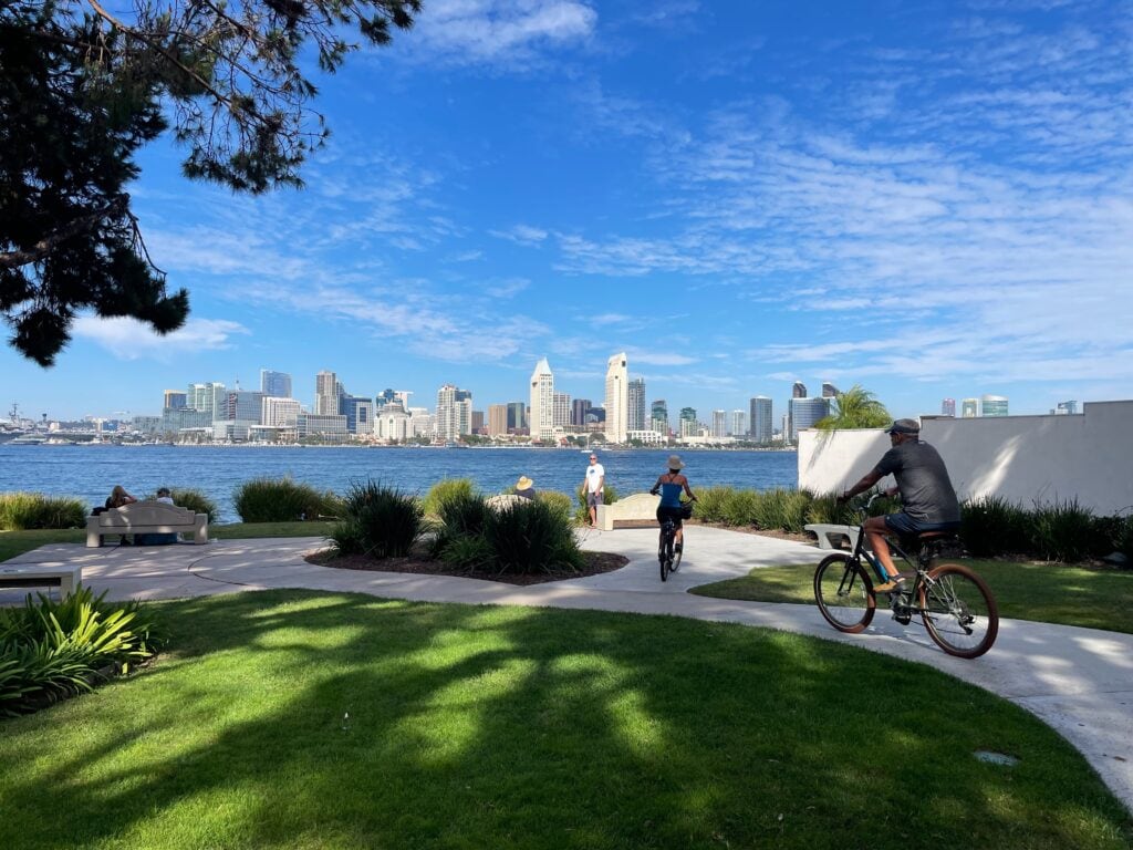 Bikers use the path at Bayview park with a view of the bay of San Diego.