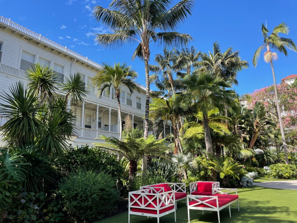 Red cushioned seats and palms trees surrounding the courtyard in Hotel del Coronado.