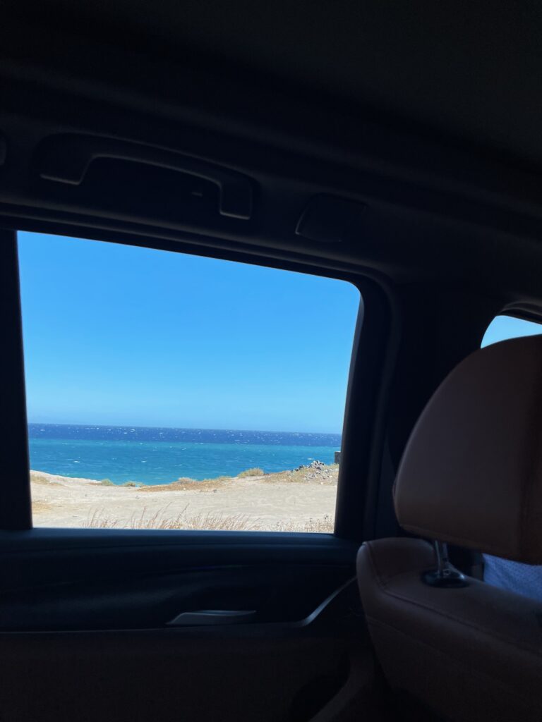 A car window view of Perissa beach in Santorini.