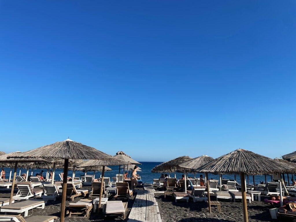A sunny day and a view of Perissa beach in Santorini.