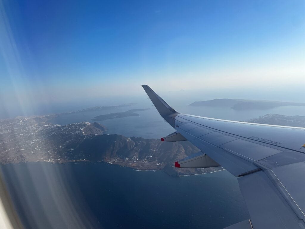 Bird's eye view of the island of Santorini from the window seat of an airplane.